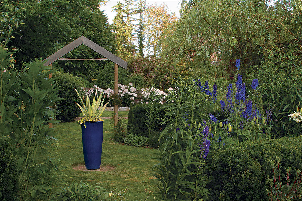 a tall blue glazed pot in garden